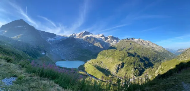 Ein Bergsee im Tal, dahinter Gletscher und Gipfel.