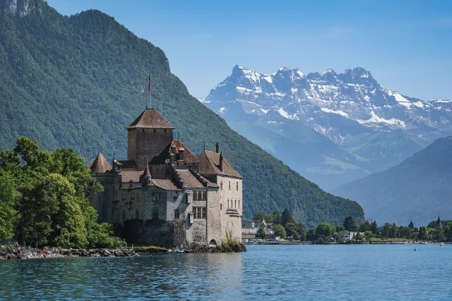 Das Schloss Chillon am Genfersee, dahinter die verschneiten Dents du Midi.
